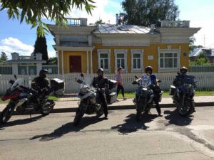 viajeros estacionados en moto frente a casa amarilla