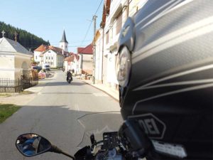 motociclista entrando a pueblo por camino pequeño